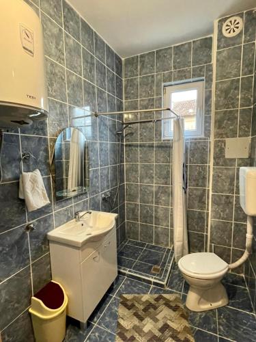 a bathroom with a toilet and a sink and a shower at Apartman Start in Pale