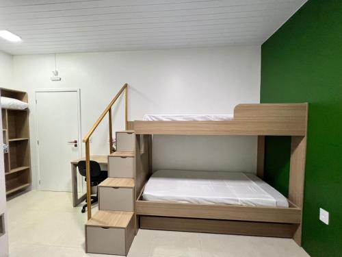 a bunk bed in a room with a green wall at HOTEL Recanto dos Bambus em PALMEIRINHA in Guarapuava