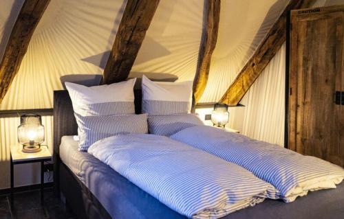 a bed with blue and white pillows in a room at Wassermühle Deppendorf in Bielefeld