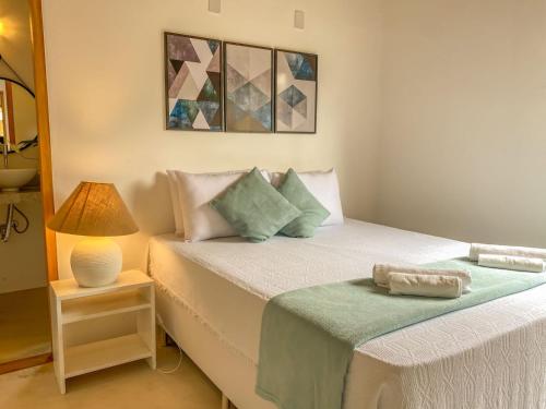 a small bedroom with a bed and a lamp at CASA RENASCER in Trancoso