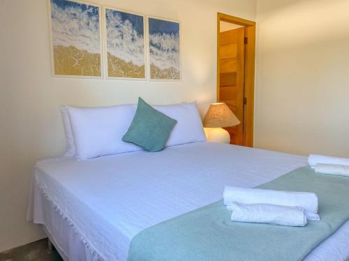 a bedroom with a white bed with blue pillows at CASA RENASCER in Trancoso