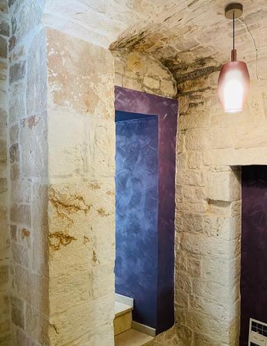 a room with a blue door in a stone wall at Antico Corso 74 in Sammichele di Bari