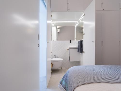 a white bathroom with a bed and a toilet at Bungalow nuevo con jardín y piscina/ Newly renovated Bungalow with private garden and swimming pool in Maspalomas