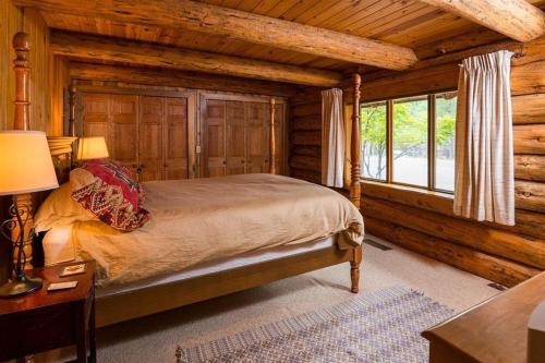 Un dormitorio con una cama en una cabaña de troncos en Sisters Dream Inn, en Sisters