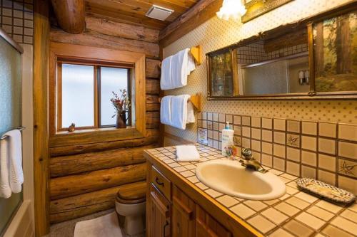 Un baño con lavabo, inodoro y espejo. en Sisters Dream Inn, en Sisters