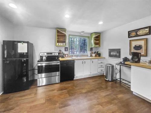 a large kitchen with black appliances and wooden floors at Bluegrass in Sisters