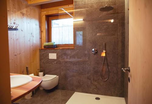 e bagno con doccia, servizi igienici e lavandino. di Laugen Lodge a San Pancrazio dʼUltimo