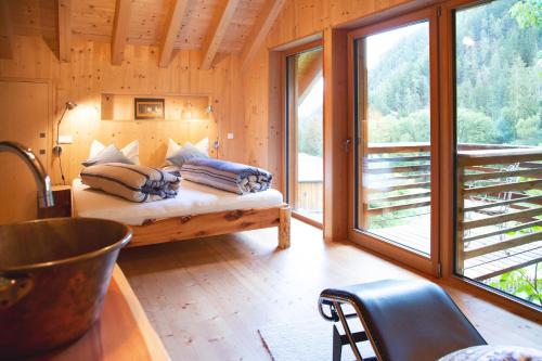 a bedroom with a bed and a large window at Laugen Lodge in San Pancrazio dʼUltimo