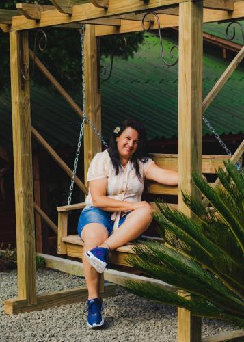 a woman is sitting on a swing at Hospedagem Rural Recanto do Riacho in Urubici