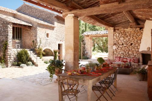 a patio with a table with food on it at Le Mas Vermentino, La Bastide de Marie, Villa avec services in Ménerbes