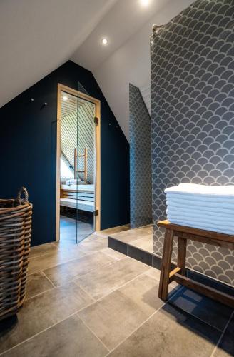 a bedroom with blue walls and a bench in a room at Jaumann's Südwind Sylt in Westerland (Sylt)