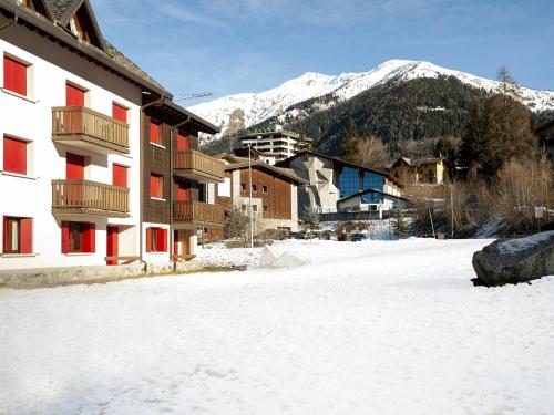 a snow covered street in front of a building at Residenze Holiday Park in Ponte di Legno