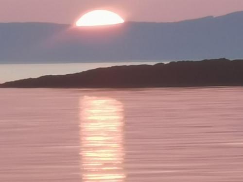 a sunset over the water with the sun in the sky at Oban Youth Hostel in Oban