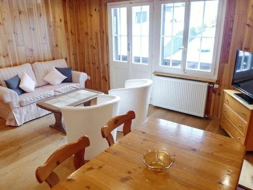 ein Wohnzimmer mit einem Tisch und einem Sofa in der Unterkunft Apartment Chalet Anna by Interhome in Grindelwald