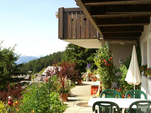 a patio with a table and chairs and flowers at Studio Wohnung 1 by Interhome in Bettmeralp