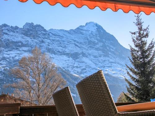 a view of a snow covered mountain with two chairs at Apartment Bodmisunne by Interhome in Grindelwald