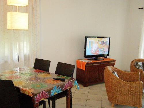 a dining room with a table and a television at Apartment Miralago - Utoring-35 by Interhome in Piazzogna