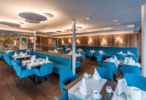 ein Restaurant mit blauen Stühlen und Tischen in der Unterkunft Aktivhotel Schweizerhof Kitzbühel in Kitzbühel