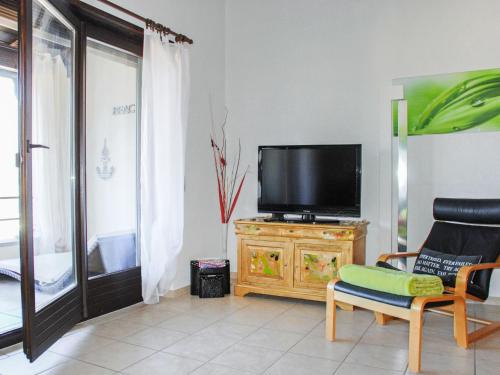 uma sala de estar com televisão num suporte de madeira em Apartment Miralago - Utoring-5 by Interhome em Piazzogna
