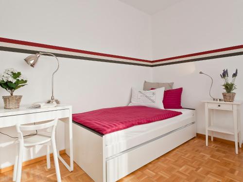 Un dormitorio con una cama blanca con sábanas rojas y un escritorio. en Apartment Large Suite by Interhome, en Ascona