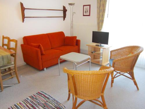 a living room with a red couch and chairs at Apartment Residenza Corallo-10 by Interhome in Ascona