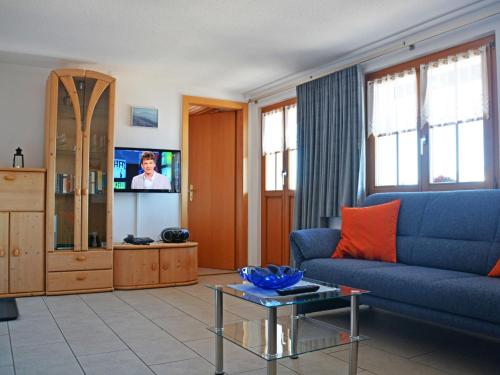 a living room with a blue couch and a tv at Apartment Wohnung 2 by Interhome in Bettmeralp
