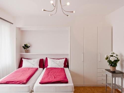 阿斯科納的住宿－Apartment Double Room-3 by Interhome，白色客房的两张床,配有红色床单