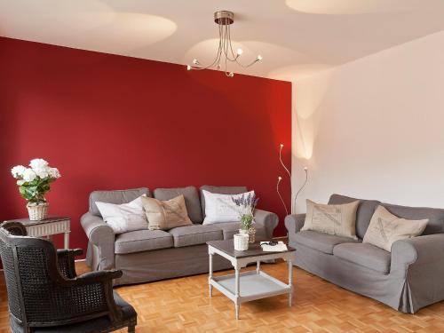 a living room with two couches and a red wall at Apartment Large Suite by Interhome in Ascona