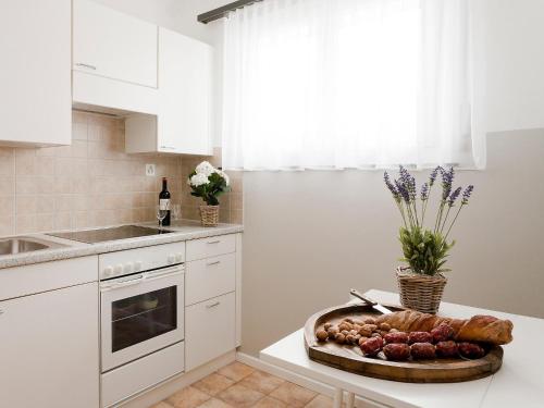 a white kitchen with a plate of food on a counter at Apartment Junior Suite-12 by Interhome in Ascona