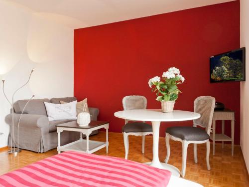アスコナにあるApartment Double Room-5 by Interhomeの白いテーブルと赤い壁のリビングルーム