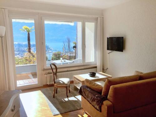 ein Wohnzimmer mit einem Sofa und einem großen Fenster in der Unterkunft Apartment Double Room Classic-8 by Interhome in Ascona