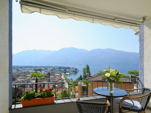 a balcony with a table and chairs and a view of the water at Apartment Double Room Modern-6 by Interhome in Ascona