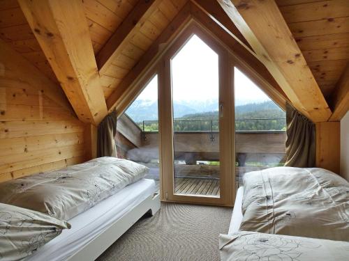 two beds in a room with a large window at Apartment Cristal Sura - 116 by Interhome in Flims