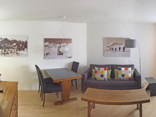 ein Wohnzimmer mit einem Sofa und einem Tisch in der Unterkunft Apartment Casa Tavaun A14 by Interhome in Flims