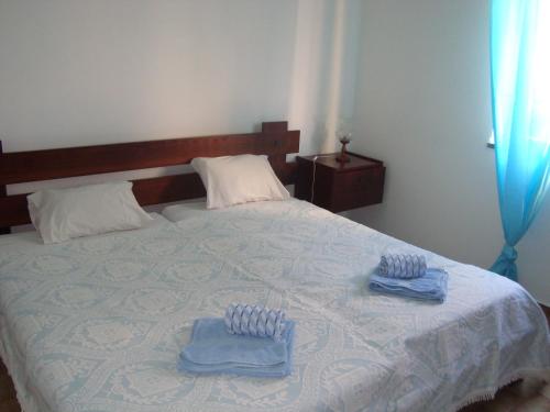 a bedroom with a bed with two towels on it at Mira Fortaleza in Sagres