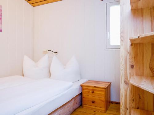 sypialnia z białymi ścianami i łóżkiem z białymi poduszkami w obiekcie Holiday Home Geesthof-1 by Interhome w mieście Klint