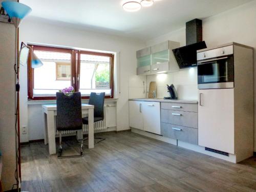 a kitchen with a table and a white refrigerator at Apartment Pension Himmelsbach by Interhome in Welschensteinach