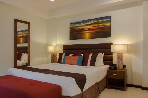 a bedroom with a large bed and a mirror at The Somerset Hotel in Male City