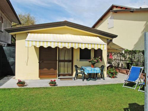 mały żółty dom ze stołem i krzesłami w obiekcie Holiday Home Casetta Mosti by Interhome w mieście Marina di Massa