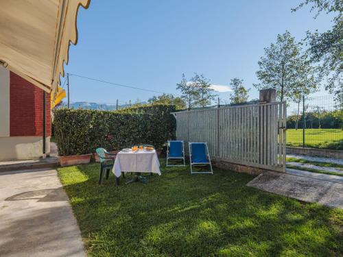 un tavolo e sedie in un cortile con recinzione di Holiday Home Casetta Mosti by Interhome a Marina di Massa