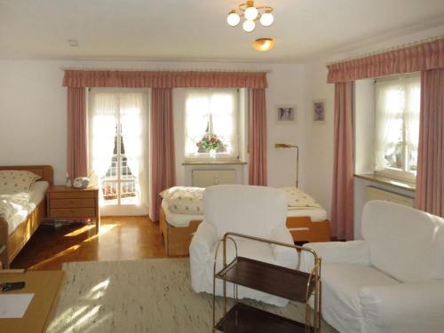 a living room with a white couch and a bed and windows at Apartment Salzburger Strasse by Interhome in Bad Reichenhall