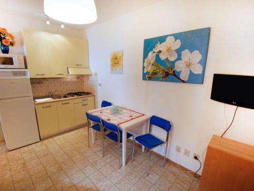 ビビオーネにあるApartment Moschettieri-1 by Interhomeのキッチン(テーブル、青い椅子付)