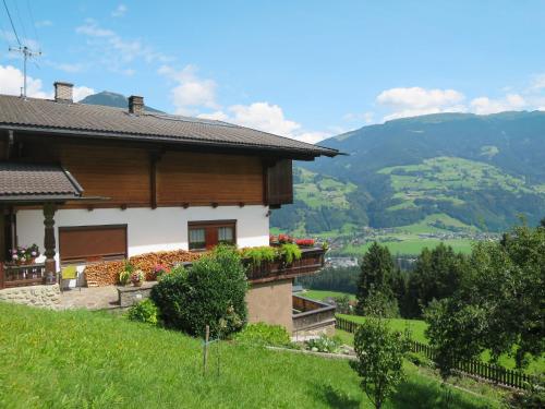 a house on a hill with mountains in the background at Apartment Häuser by Interhome in Ried im Zillertal