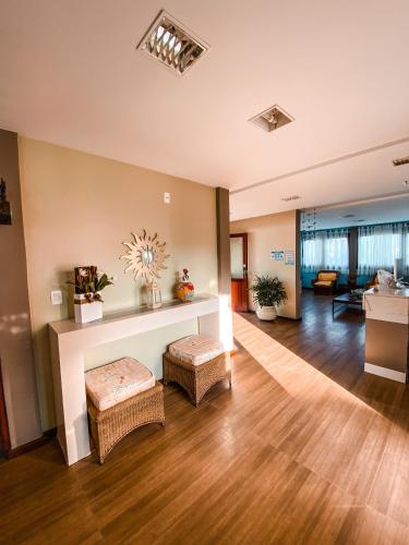 a living room with a fireplace and wooden floors at Pousada e Chale Porto Paraiso in Porto Seguro