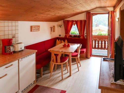 małą kuchnię ze stołem i czerwoną kanapą w obiekcie Apartment Elisabeth by Interhome w Alpbach