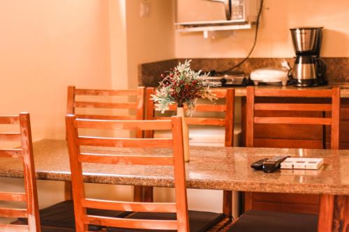 a dining room table with a vase of flowers on it at Pousada e Chale Porto Paraiso in Porto Seguro