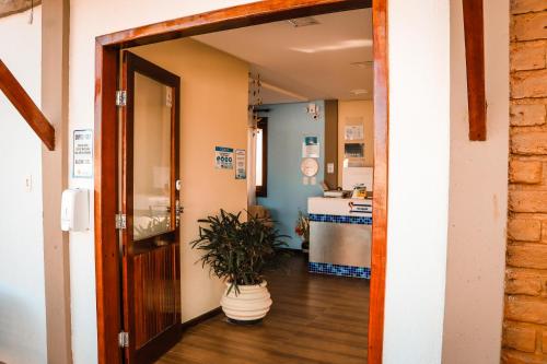 an open door to a kitchen with a potted plant at Pousada e Chale Porto Paraiso in Porto Seguro