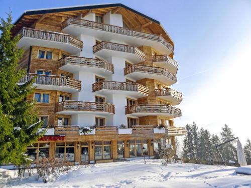 ein großes Gebäude mit Holzbalkonen im Schnee in der Unterkunft Apartment Le Bristol B52 by Interhome in Villars-sur-Ollon