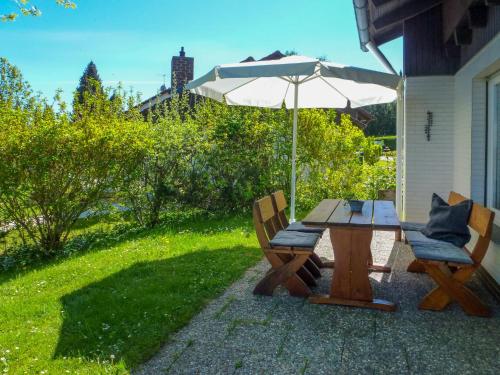 a picnic table and two chairs with an umbrella at Holiday Home Drachenfels by Interhome in Dittishausen