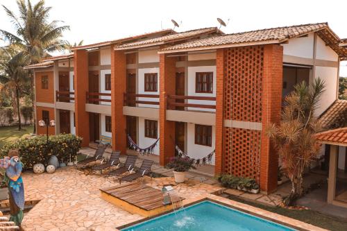 a resort with a swimming pool in front of a building at Pousada e Chale Porto Paraiso in Porto Seguro